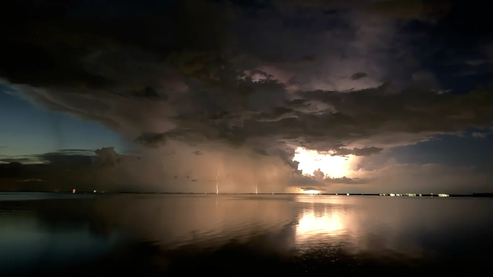 Lightning over water captured at night